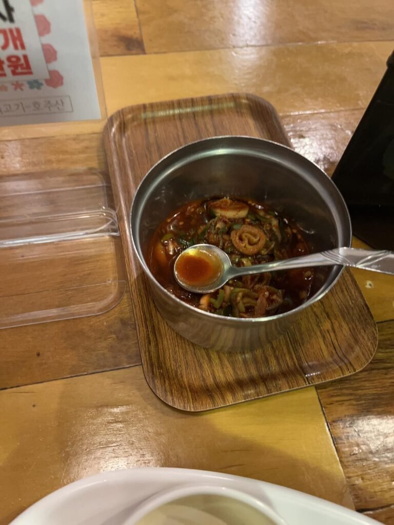 A small pot of dadaegi, Korean seasoned soy sauce with chopped peppers, served as a condiment for janchi-guksu.