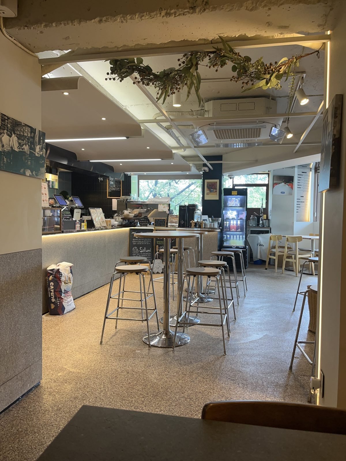Inside O Tigelle in Noksapyeong: tall round tables, the counter, and a sack of Italian flour on the floor