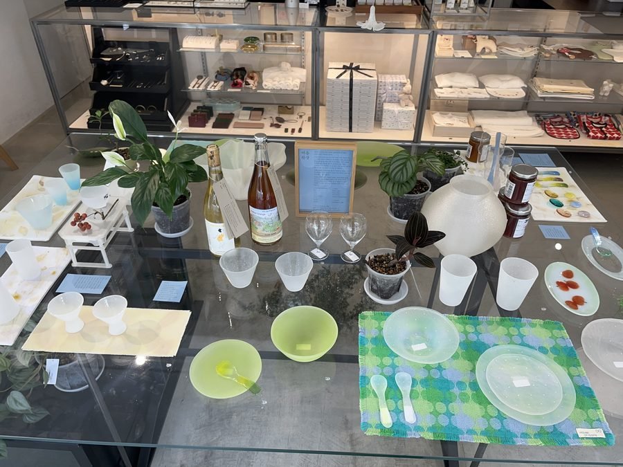 A first-floor display table set with glassware, small plates and patterned placemats.