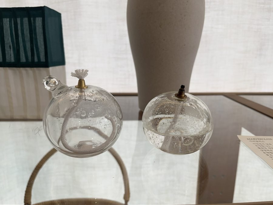 Two round glass pieces on a glass table by the window.