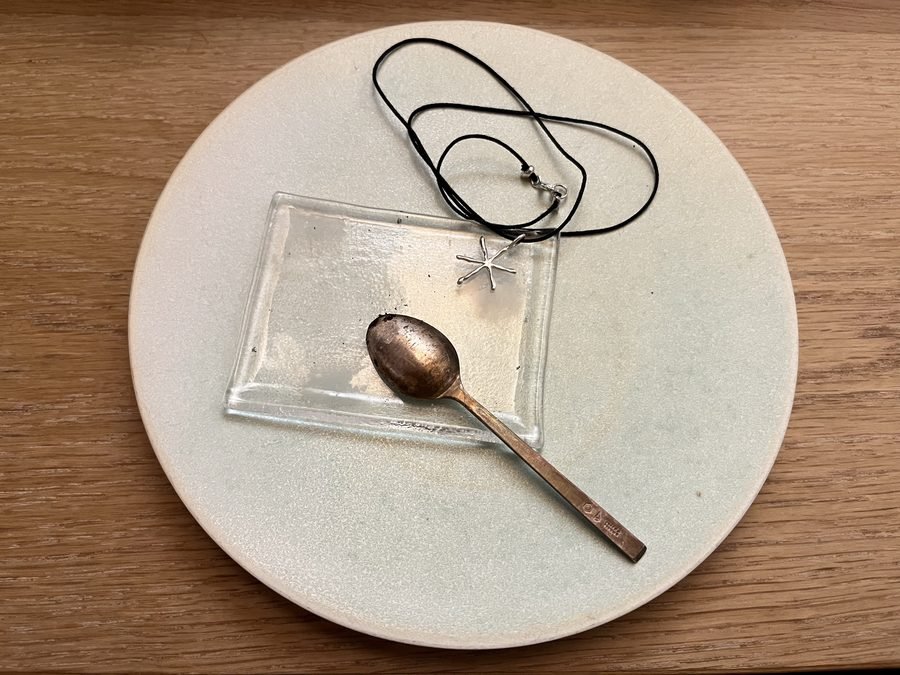 The four things I have bought at TWL: a round plate, a square glass tray, a teaspoon, and a star charm on a black cord.
