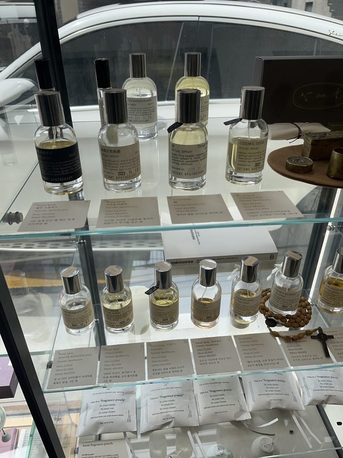 Rows of glass spray bottles in a glass case.