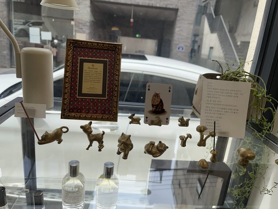 Small metal animal figures and a framed picture in a glass case.
