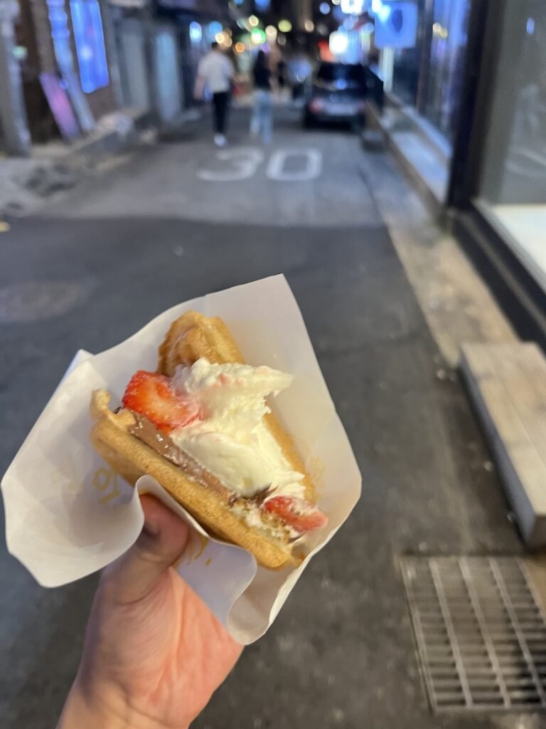 Half a Waffle University waffle, held on an Itaewon street at night